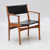 Armchairs in teak, seat and back with upholstery covered in black leather.